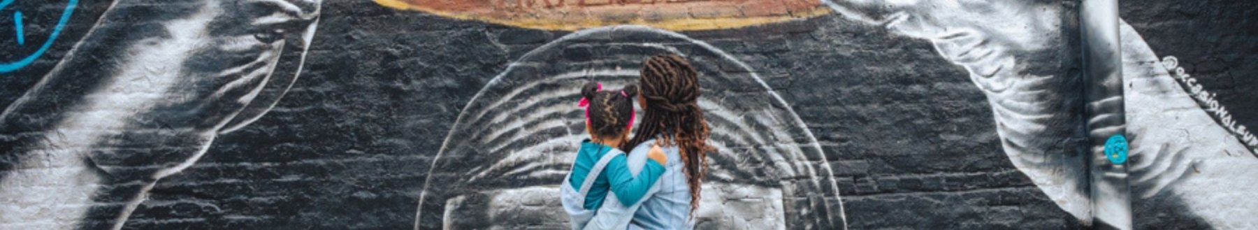 mom and daughter looking at mural in west end