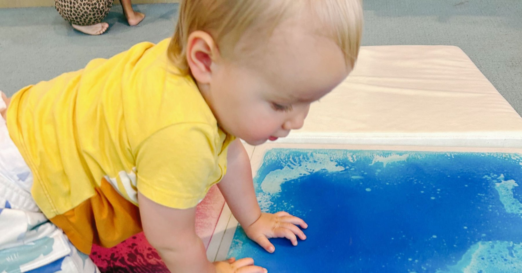 baby playing with art mat